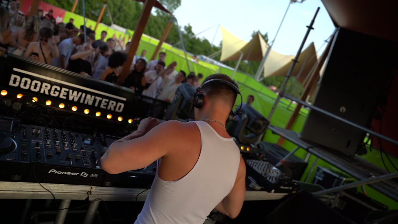 DJ met de armen omhoog in het avondlicht op Doorgewinterd